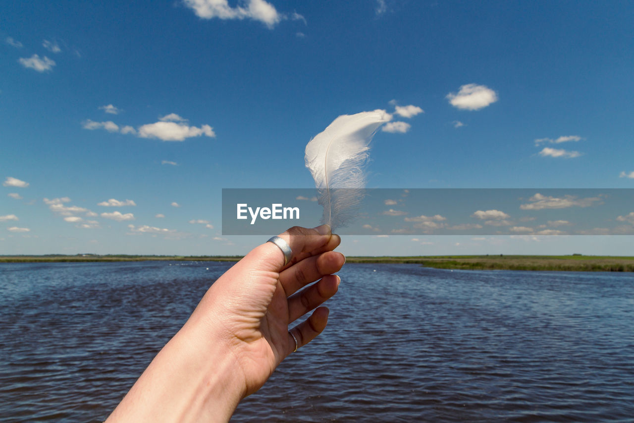 Close up feather in hand concept photo