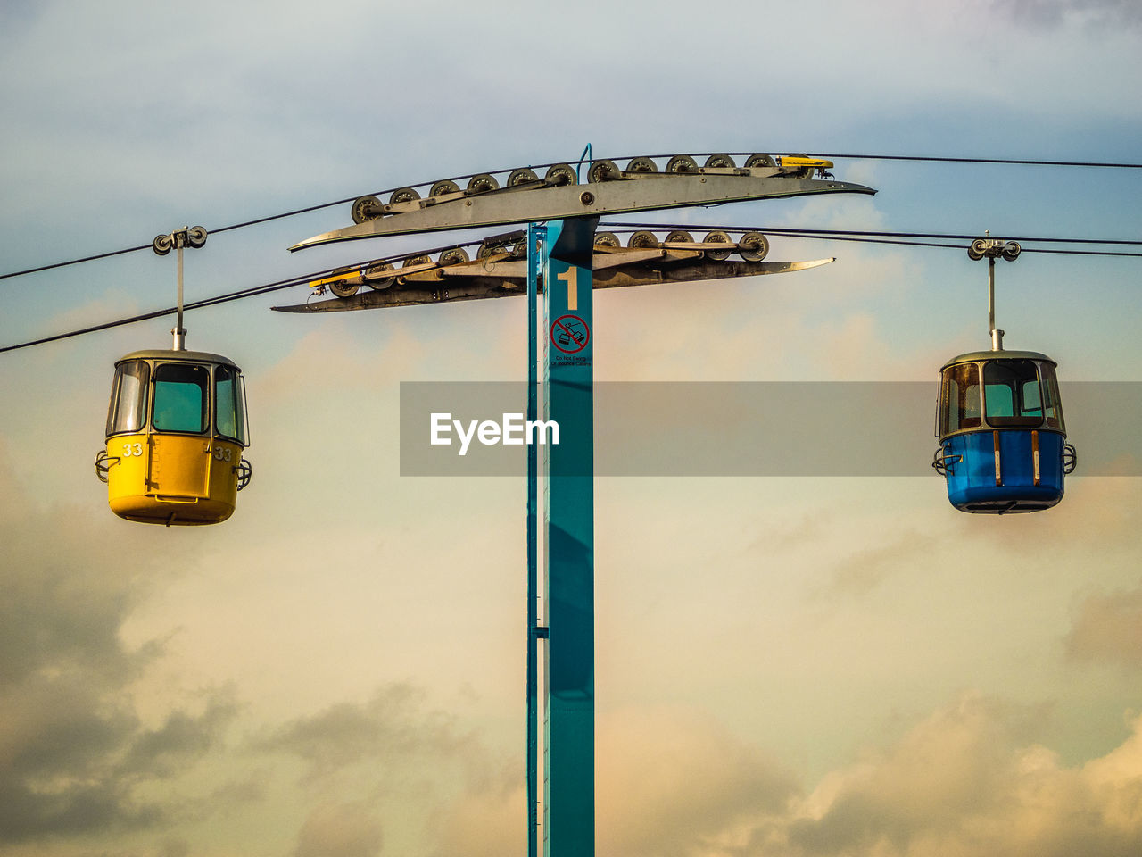 Low angle view of overhead cable car against sky