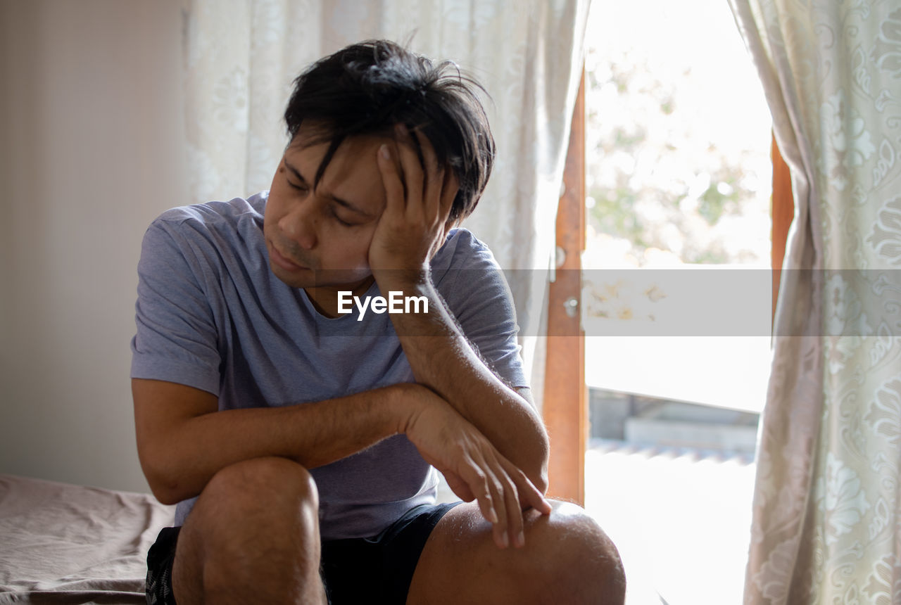 MID ADULT MAN SITTING AT HOME
