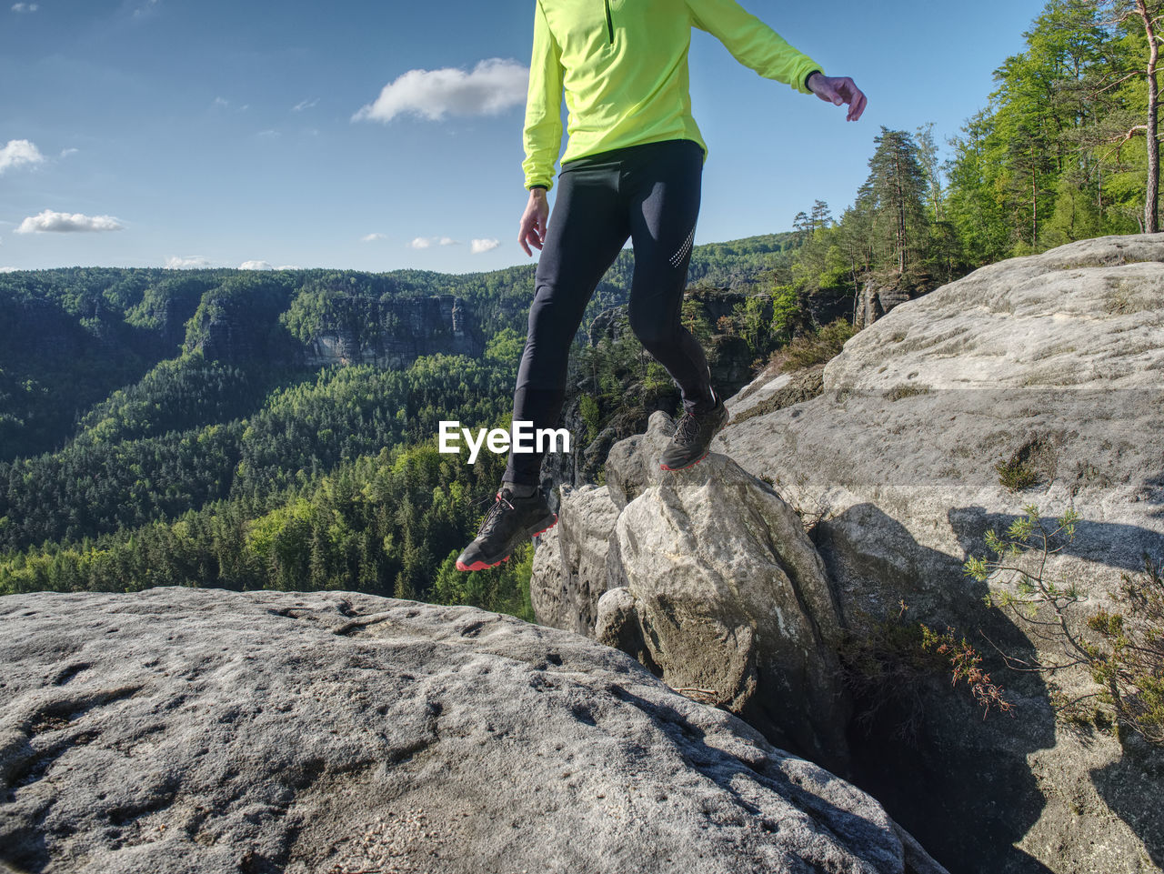 Sport athlete runner man in mountain trail. fitness man runner running on sunrise mountain top edge