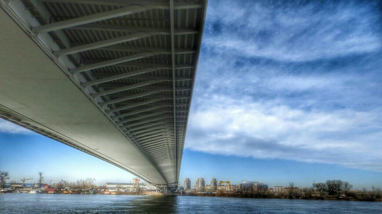 LOW ANGLE VIEW OF BRIDGE OVER RIVER AGAINST SKY