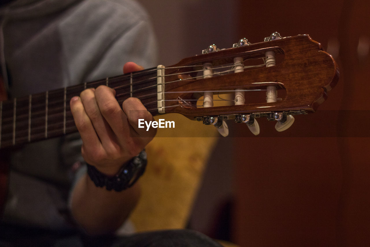 Cropped hand of man playing guitar