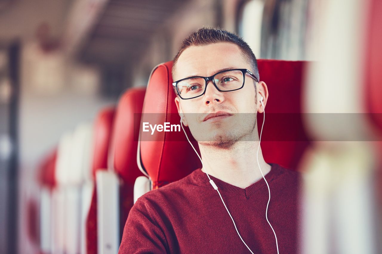 Young man listening to music while traveling in train