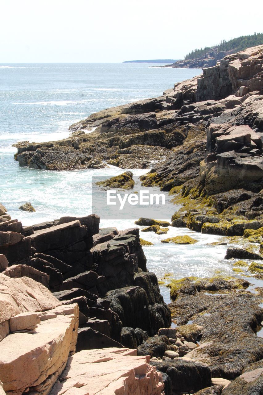 ROCKS ON BEACH AGAINST SKY