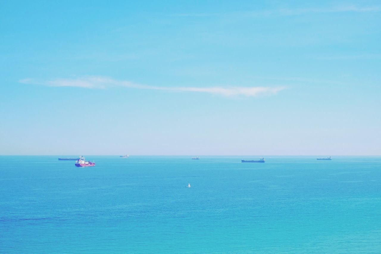 Contain ships sailing on blue sea against sky