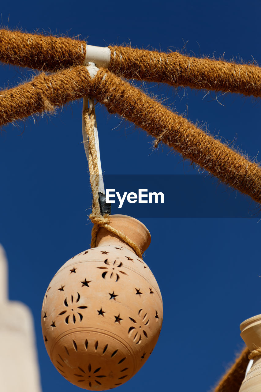 Low angle view of decoration hanging against clear blue sky