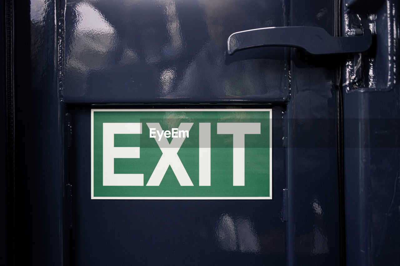 Exit sign on black metal door