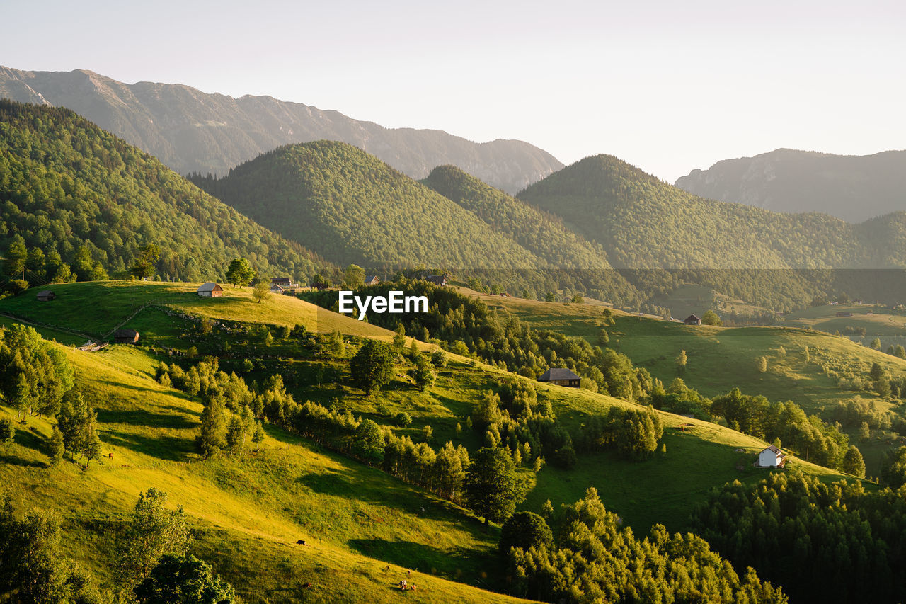 Scenic view of summer landscape and mountains against sky in the morning