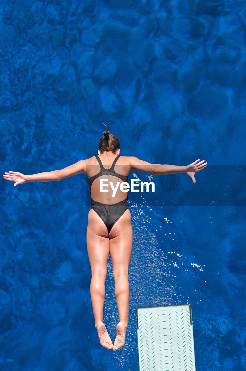 Directly above shot of woman jumping in swimming pool