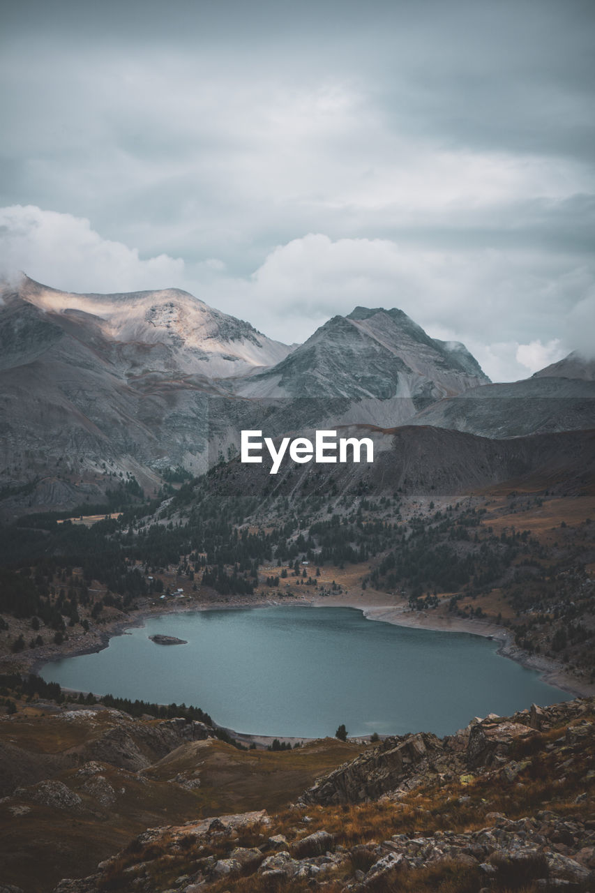 Scenic view of lake by mountains against sky