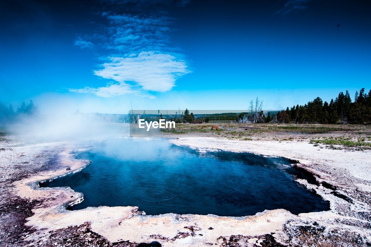 Scenic view of hot spring against sky