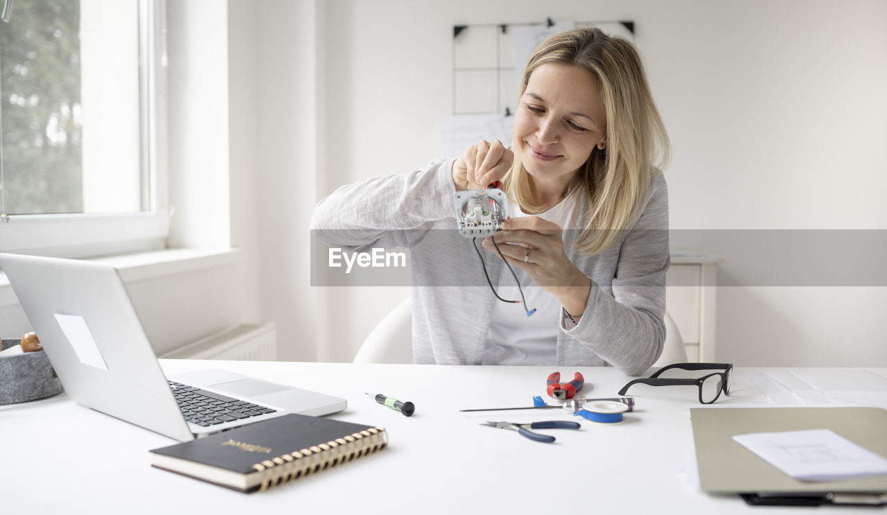 Young woman using phone on table
