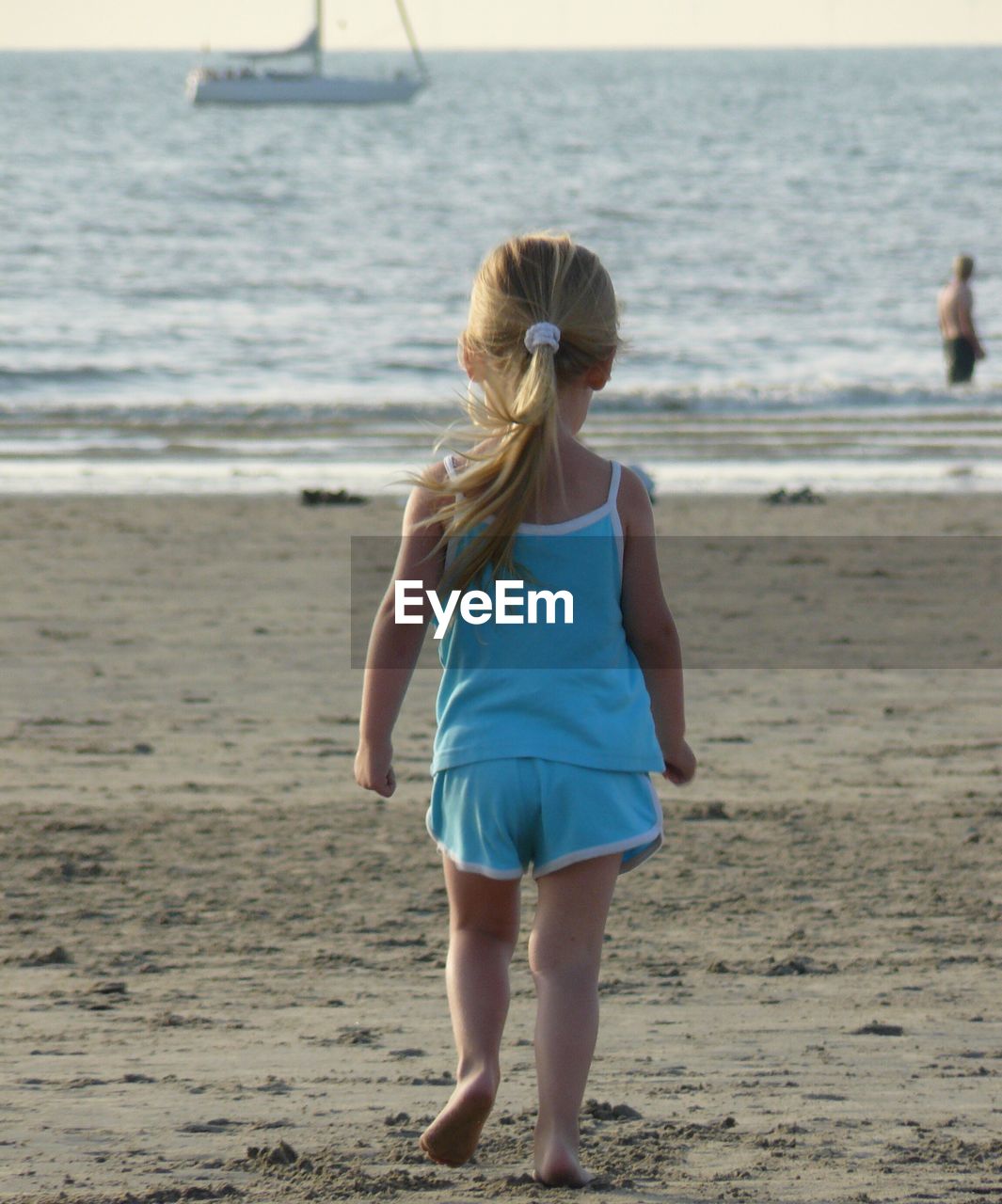 Rear view of girl walking on beach