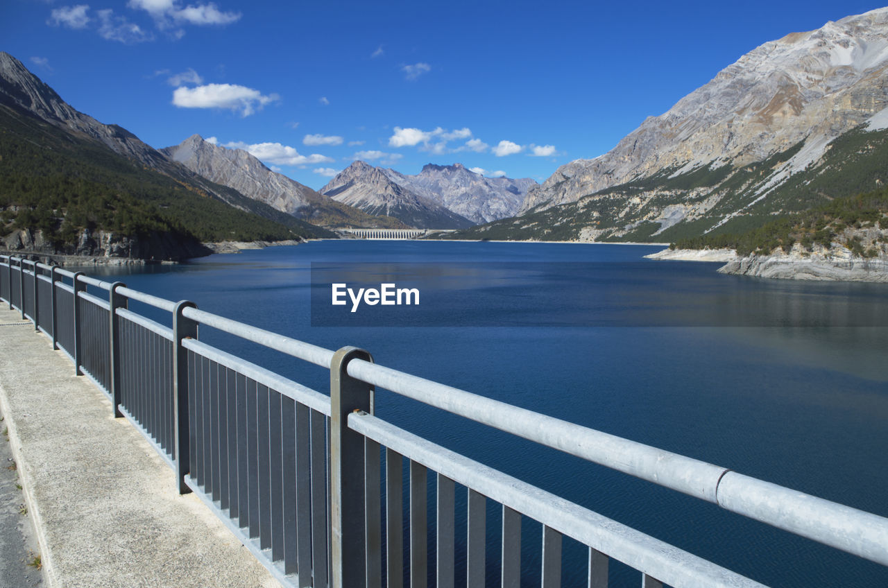 Scenic view of lake and mountains against blue sky