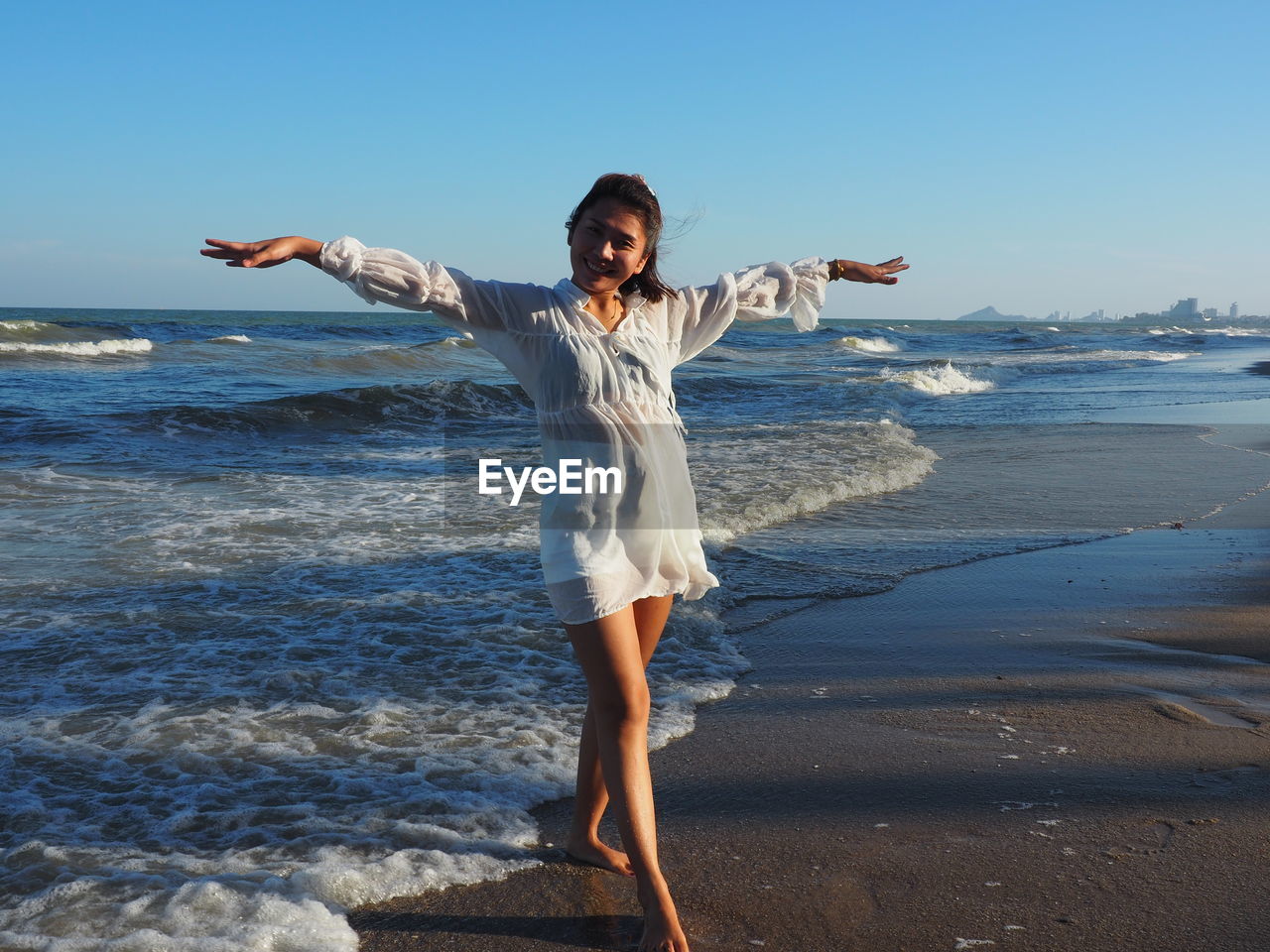 Full length of happy woman standing on beach