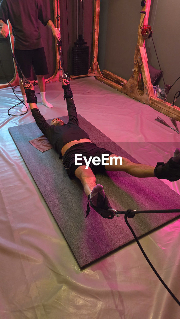 performance, performance art, stage, adult, performing arts, entertainment, indoors, lifestyles, human leg, clothing, low section, arts culture and entertainment, pink, red, one person, lying down, sports