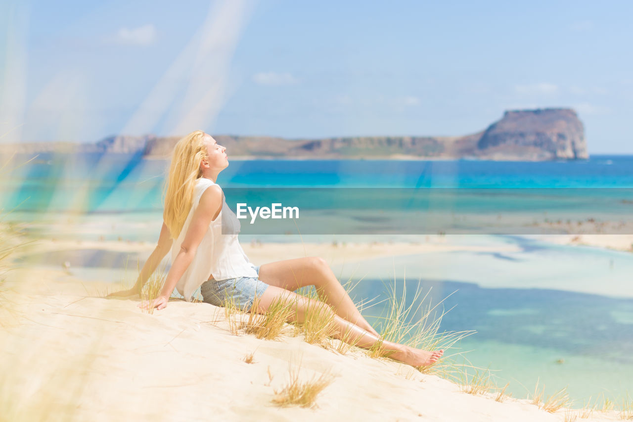 WOMAN ON BEACH AGAINST SKY