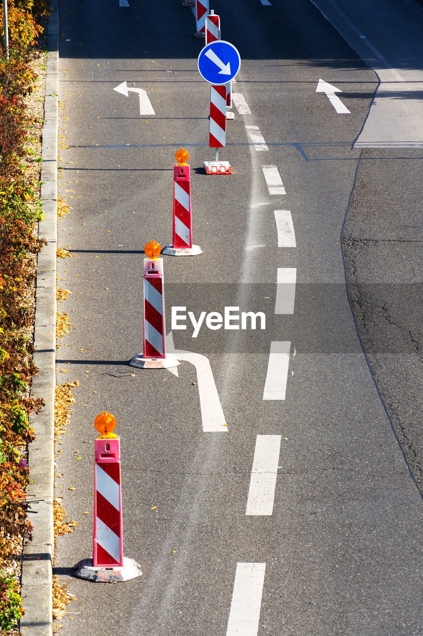 HIGH ANGLE VIEW OF ROAD SIGNS ON STREET