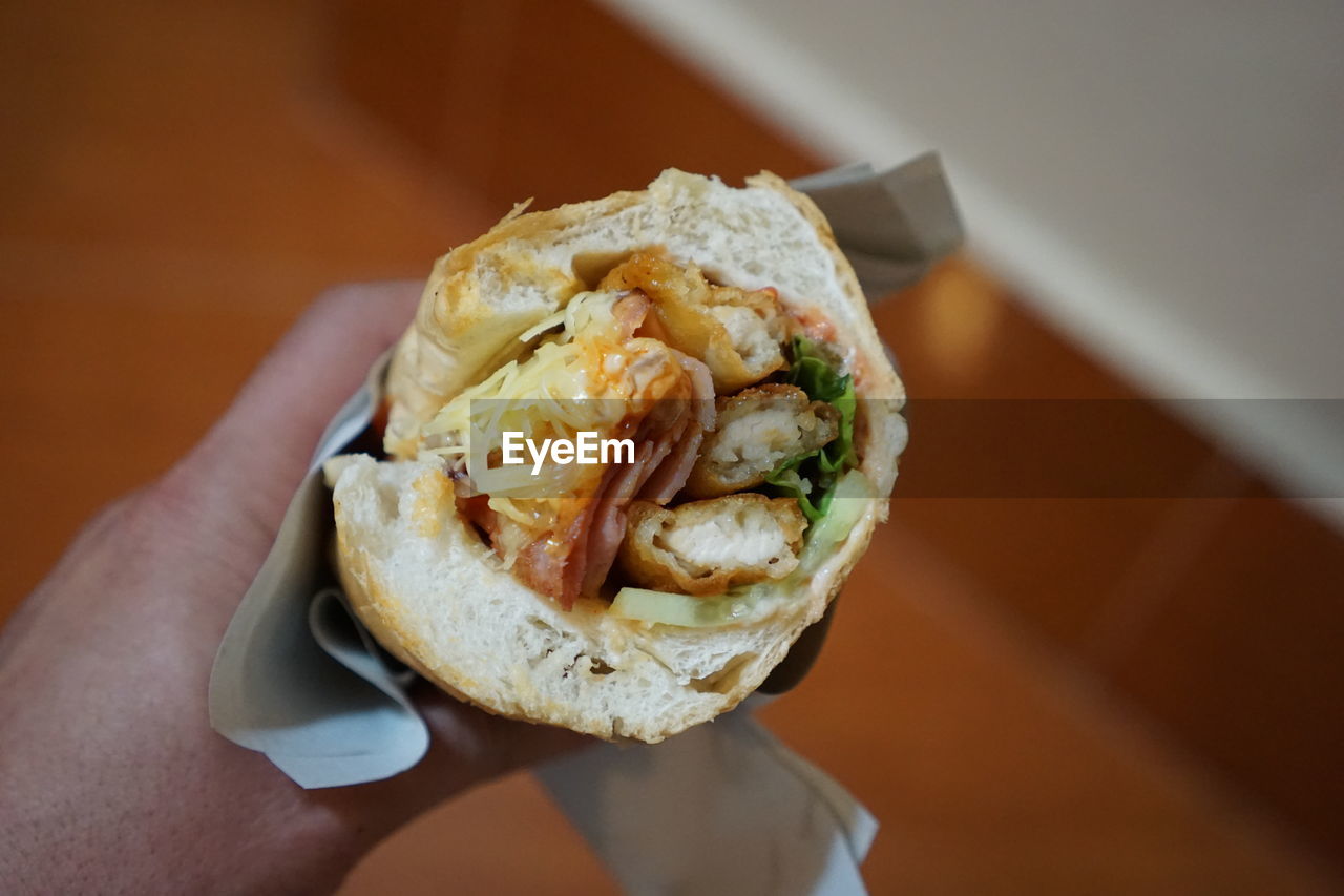 CLOSE-UP OF HAND HOLDING BREAD