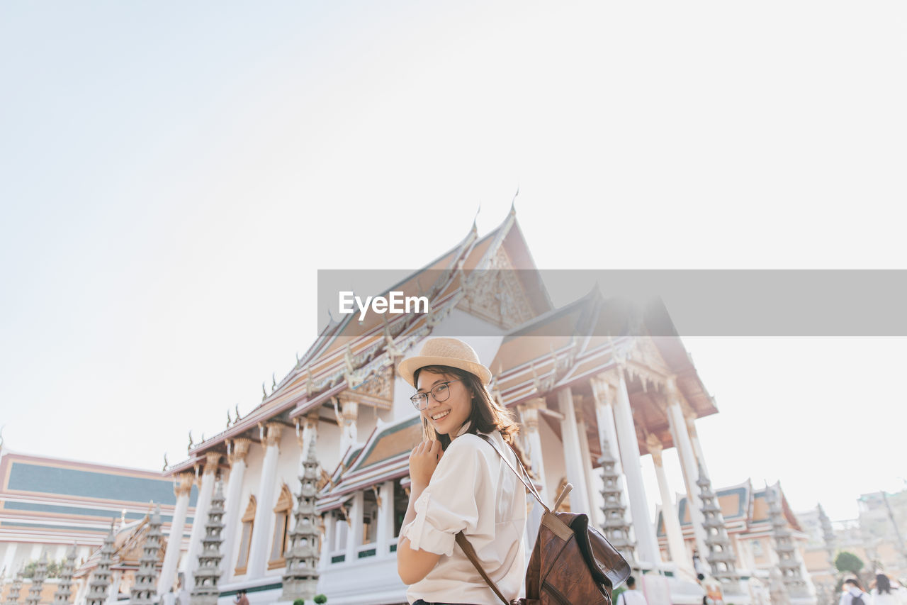 Tourist woman at wat suthat thepwararam ratchaworamahawihan temple, bangkok, thailand