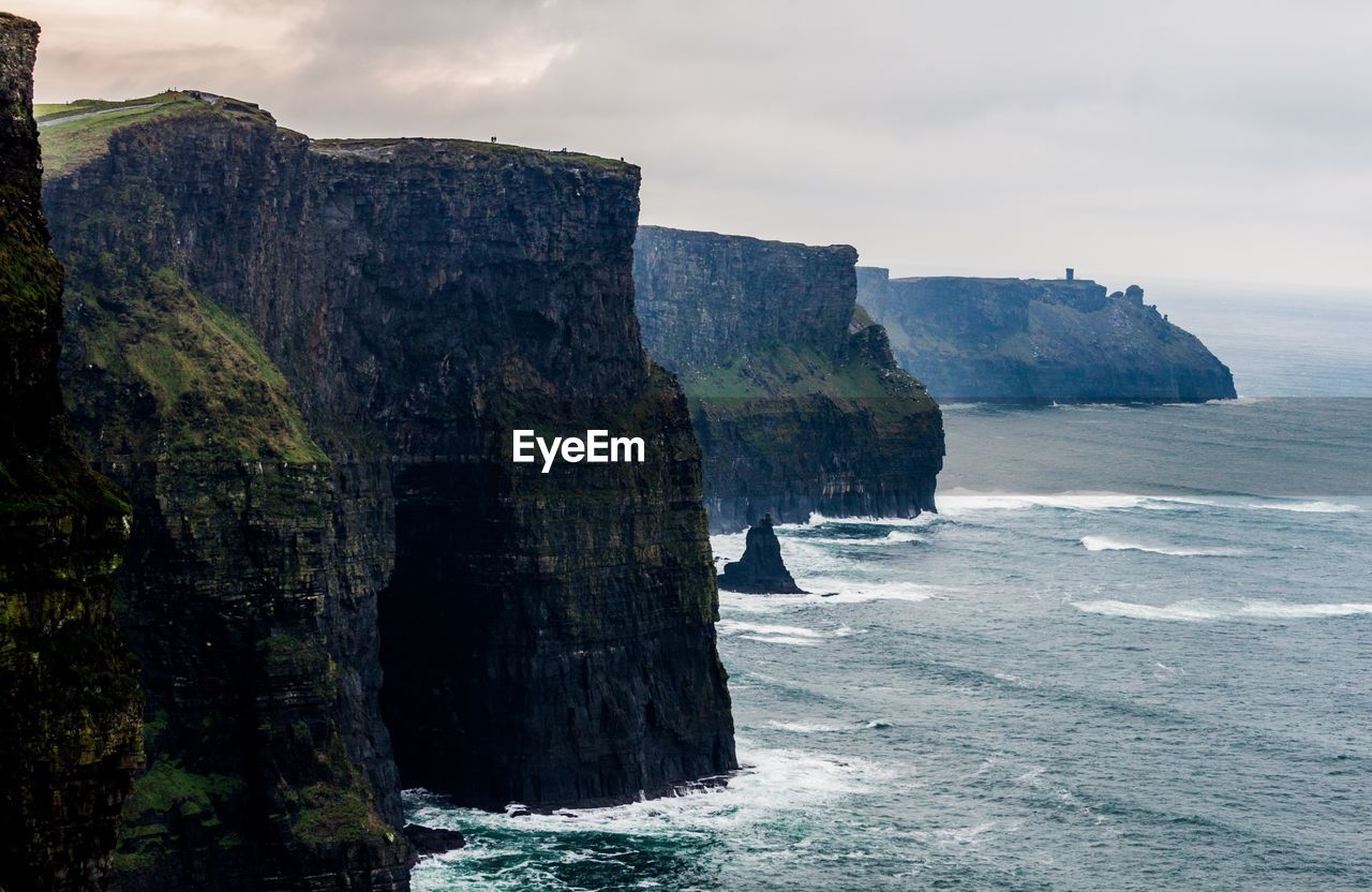 Cliffs by sea against sky