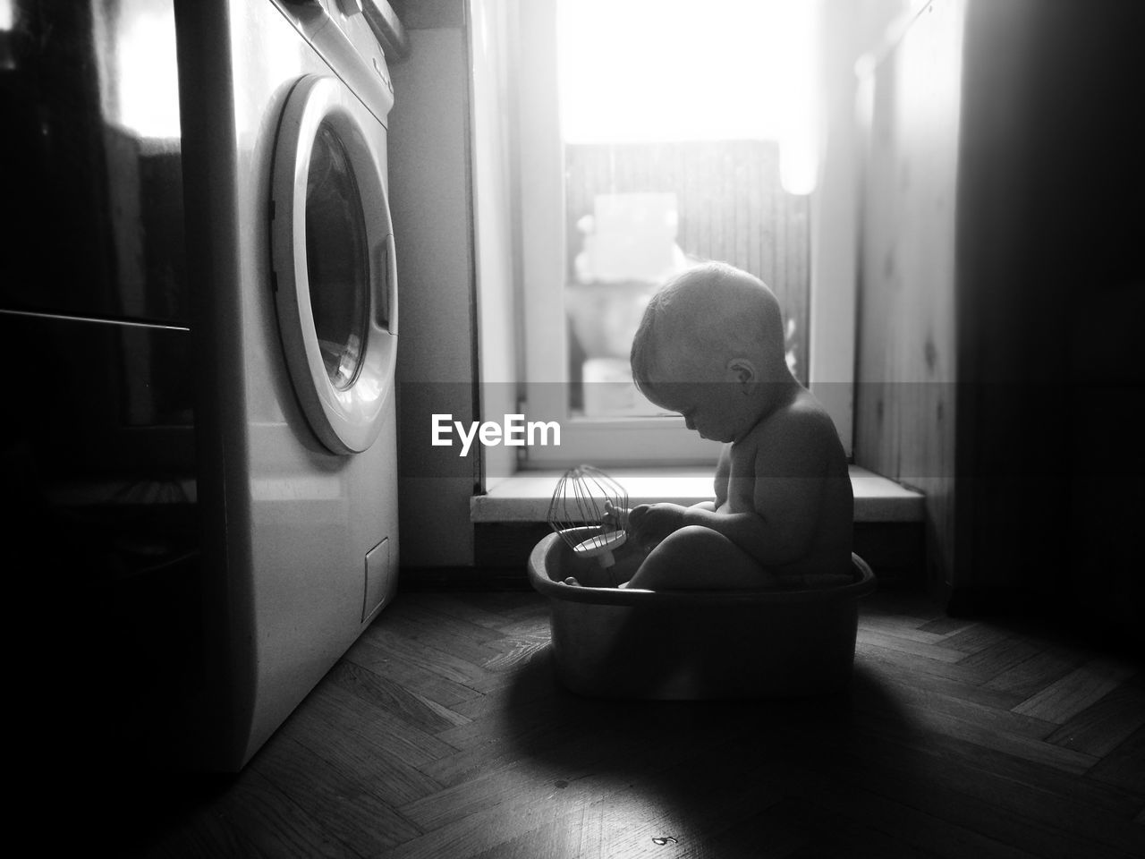 Cute boy sitting in tub at home