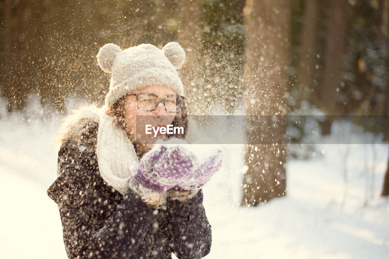 YOUNG WOMAN IN SNOW COVERED WITH UMBRELLA