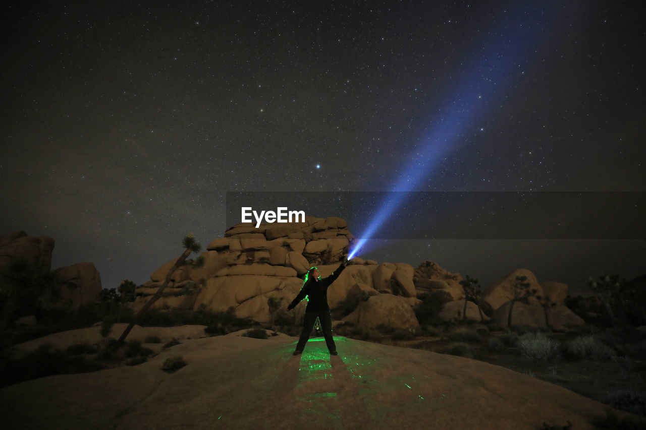 Man standing on mountain against sky at night