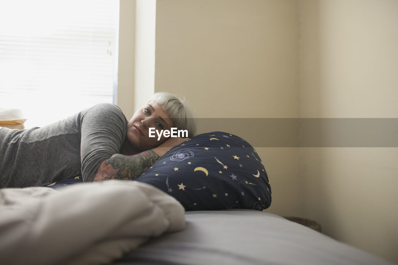 Young woman lying in bed