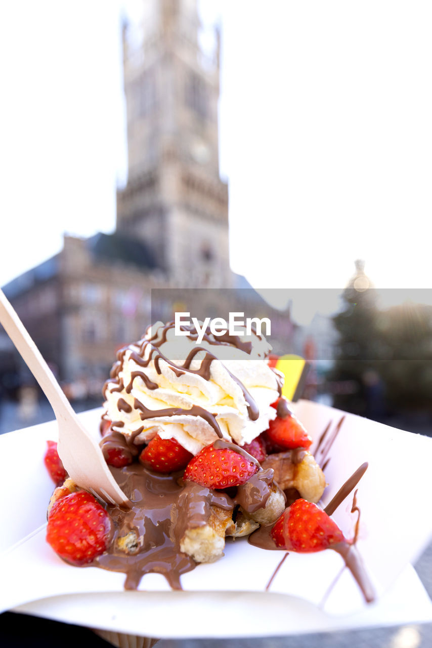 food and drink, food, dish, sweet food, freshness, meal, sweet, sundae, dessert, fast food, fruit, breakfast, plate, frozen, frozen food, ice cream, no people, architecture, produce, healthy eating, city, dairy, focus on foreground, nature, building exterior, eating utensil, temptation, strawberry