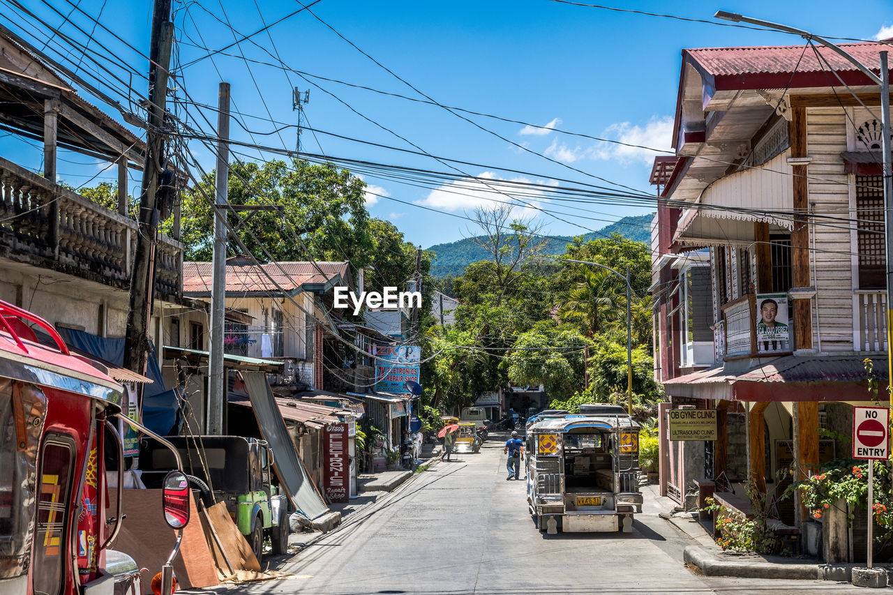 STREET AMIDST BUILDINGS AGAINST SKY