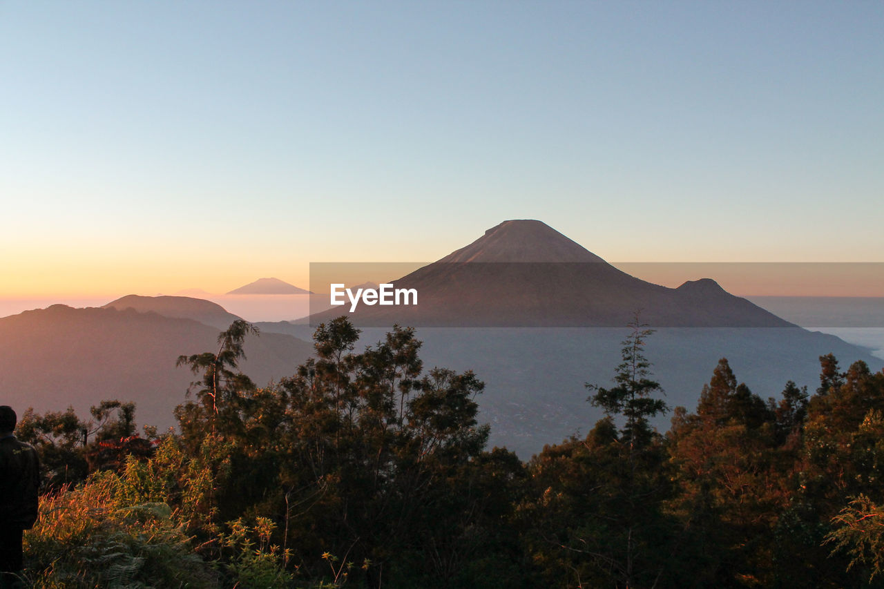 Scenic view of mountains against clear sky during sunset