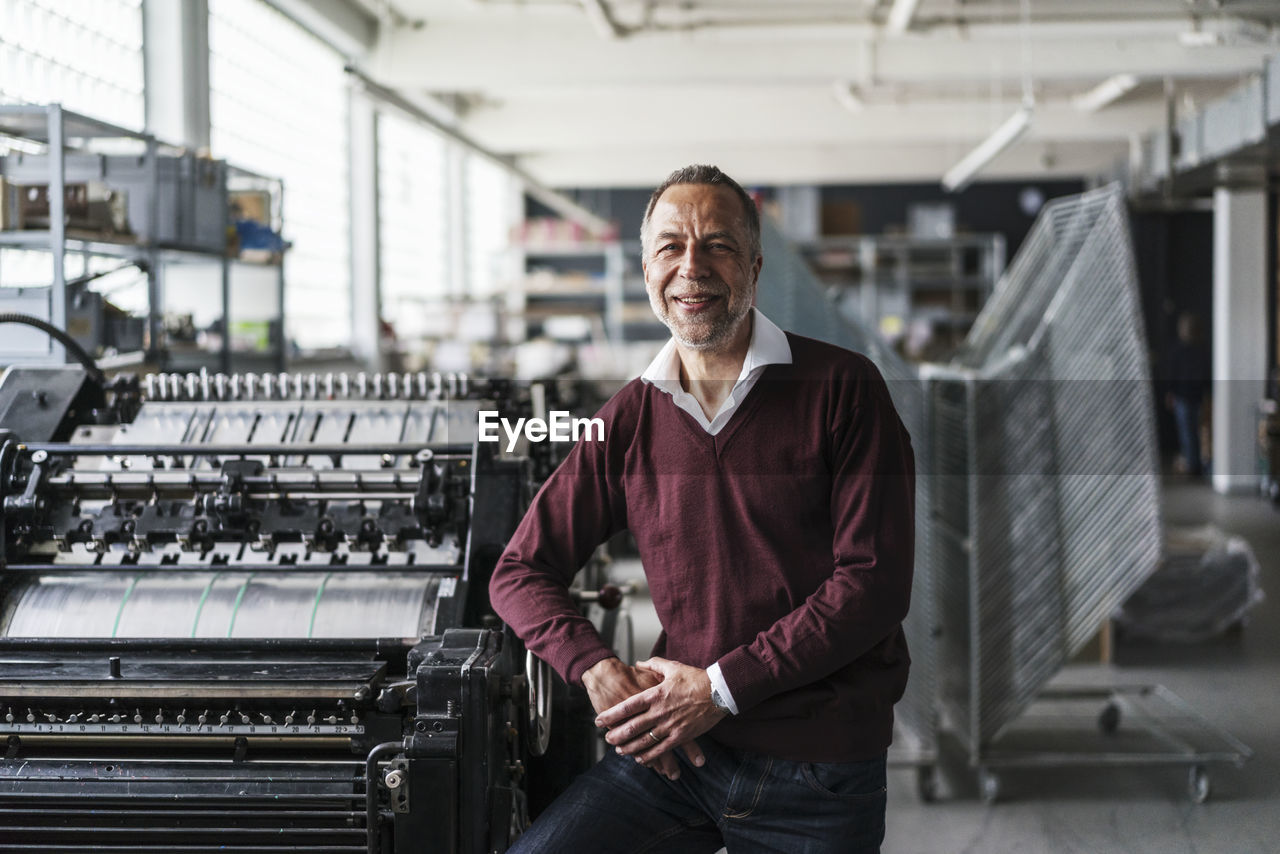 Smiling mature man in a printing shop