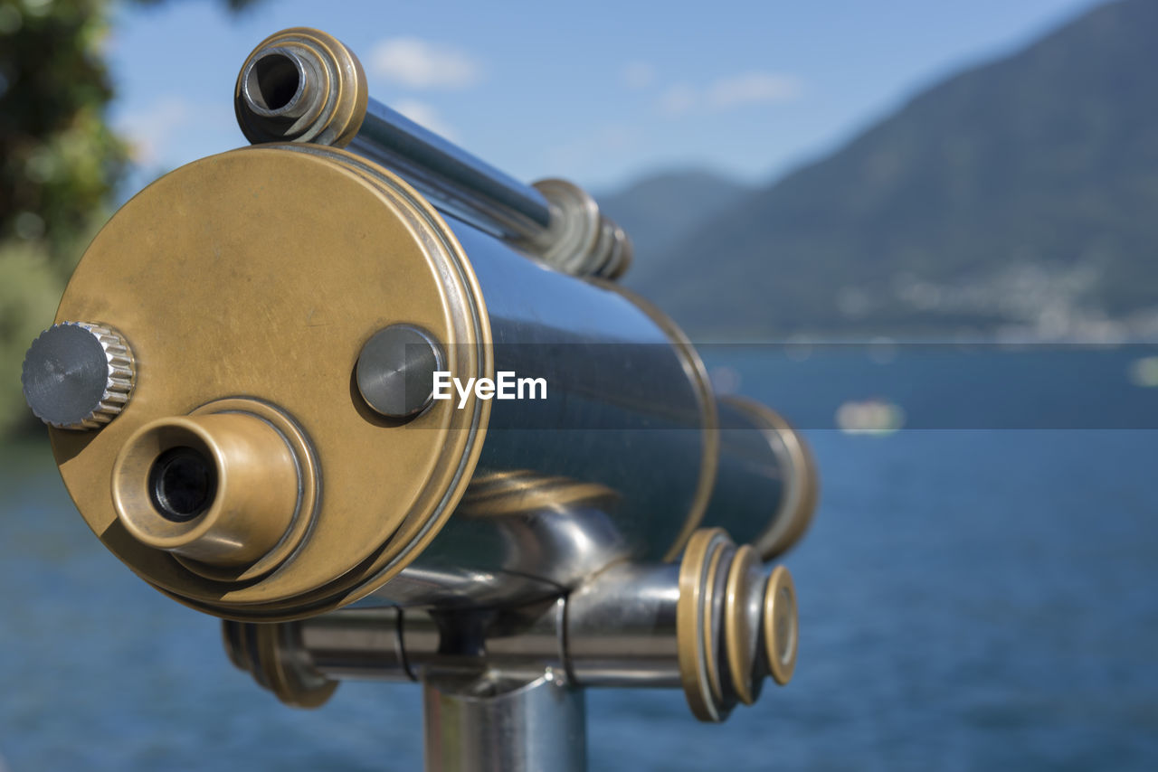 Close-up of coin-operated binoculars against sea