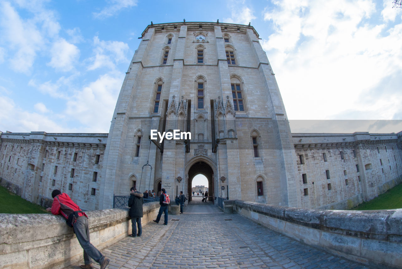 LOW ANGLE VIEW OF PEOPLE WALKING OUTSIDE TEMPLE