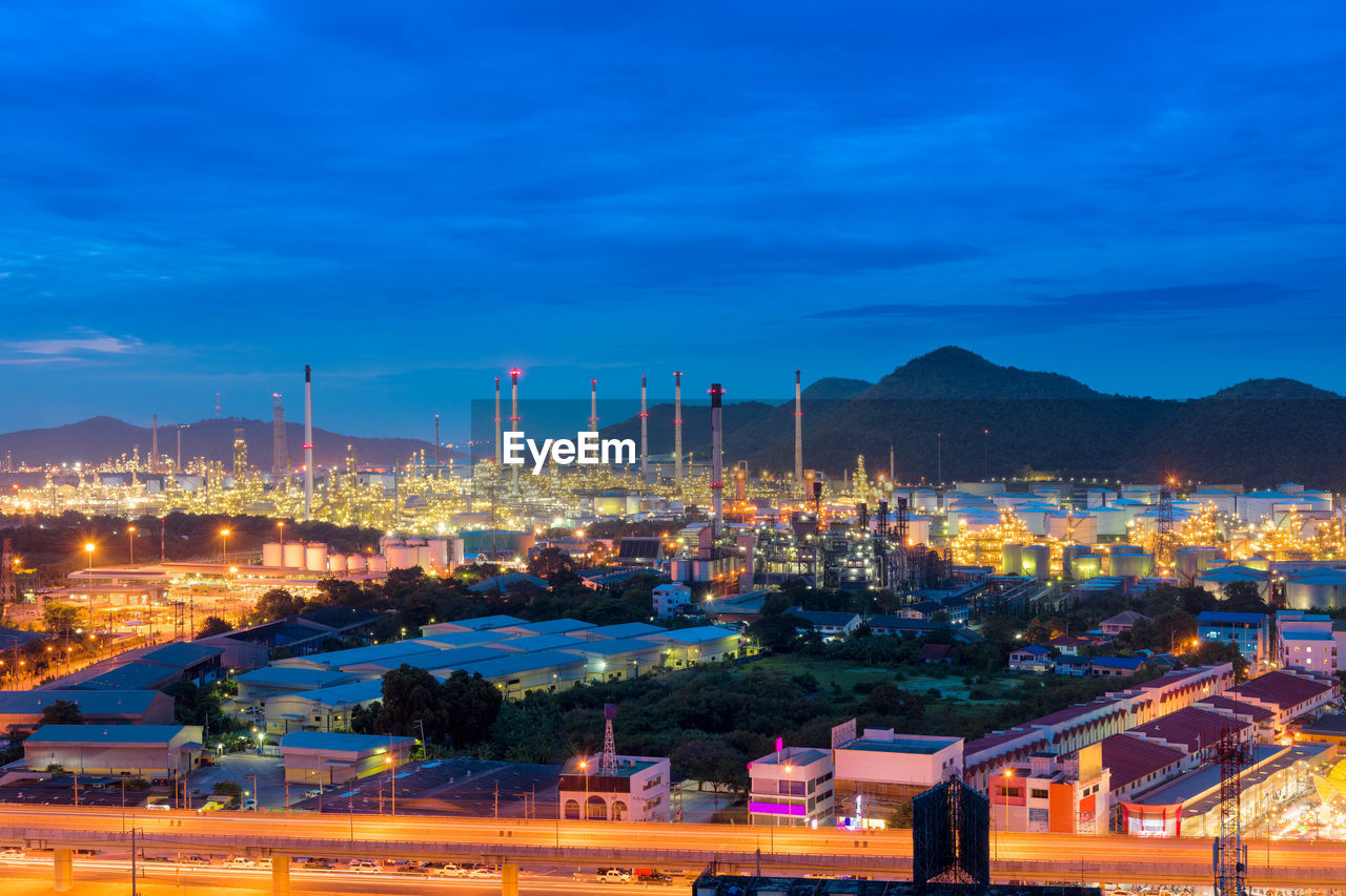 HIGH ANGLE VIEW OF ILLUMINATED CITY AT DUSK