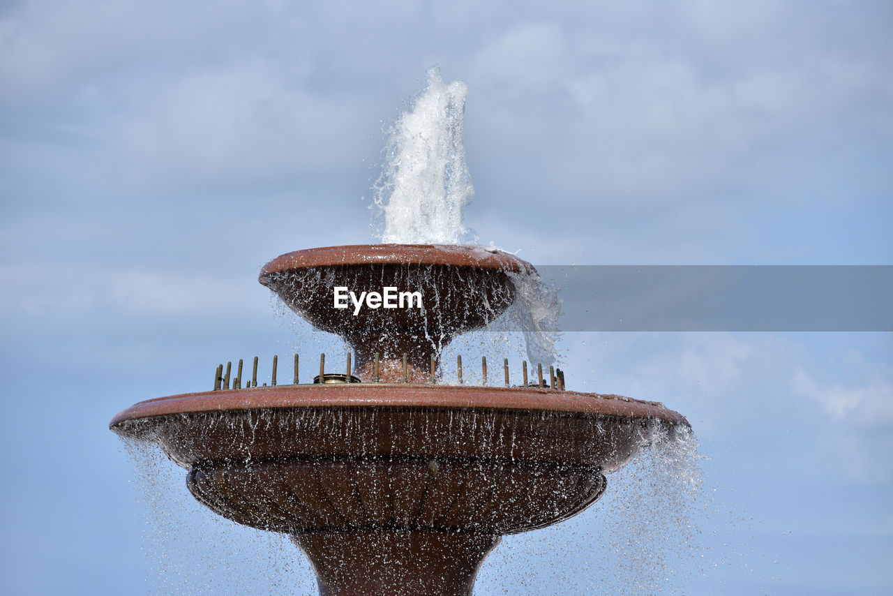 LOW ANGLE VIEW OF FOUNTAIN IN WATER AGAINST SKY