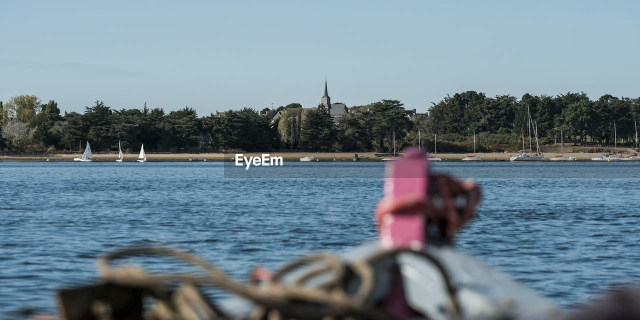 BICYCLE BY RIVER AGAINST SKY