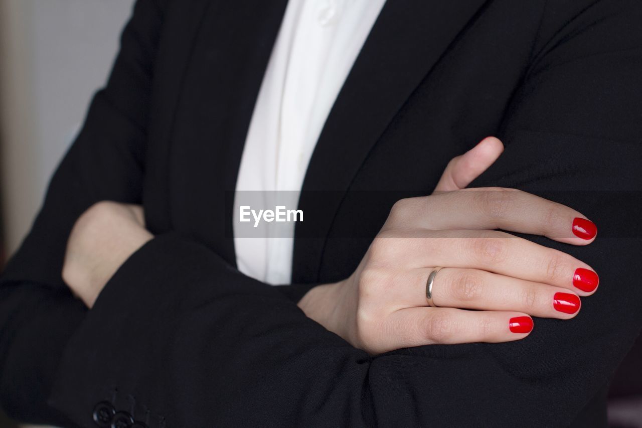 Midsection of businesswoman with red nail polish 