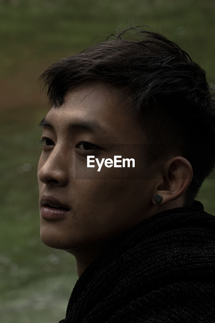 Close-up of young man looking away outdoors
