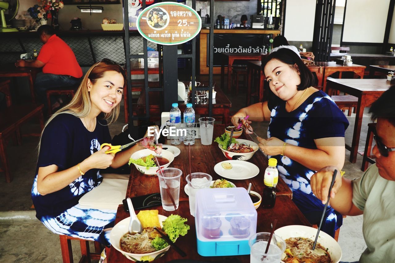 YOUNG WOMAN HAVING FOOD AT RESTAURANT