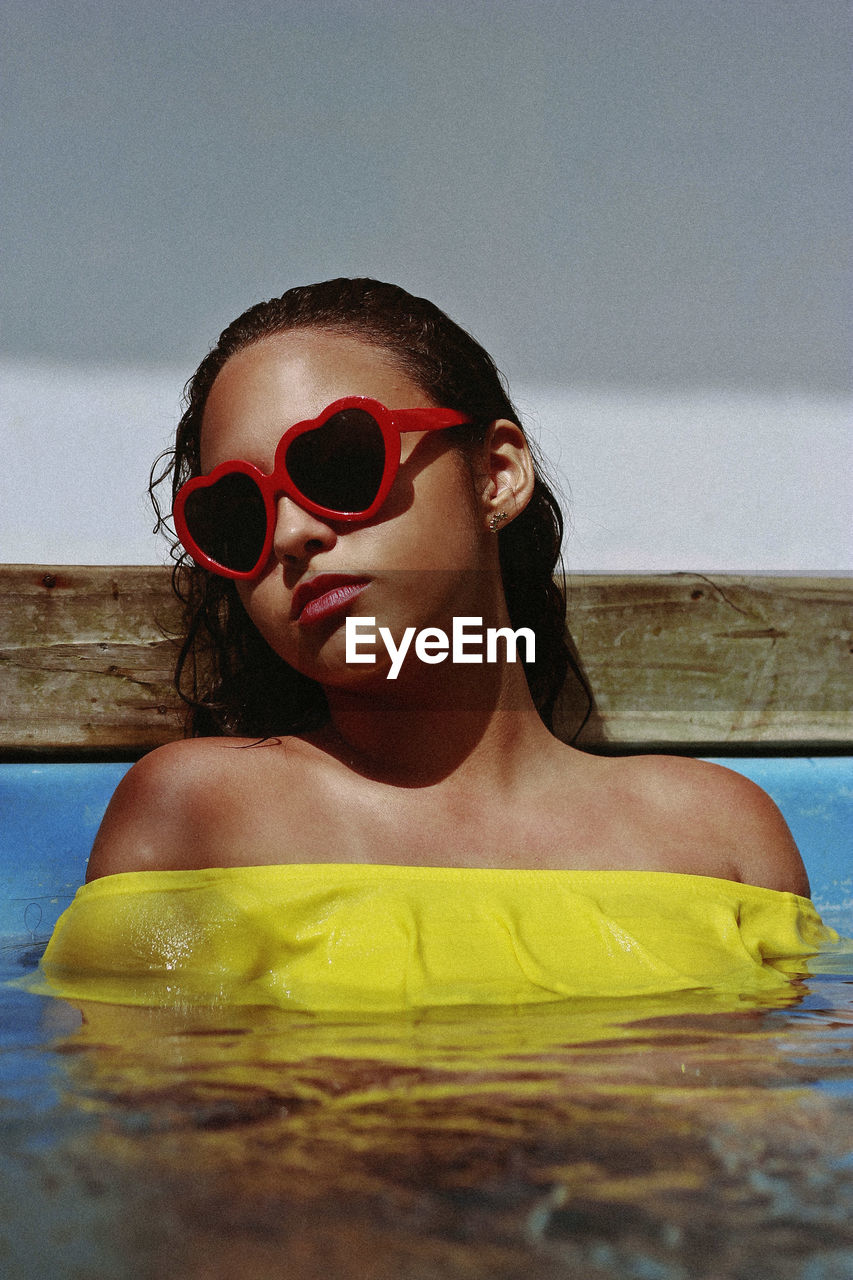 Close-up of teenage girl wearing sunglasses in swimming pool