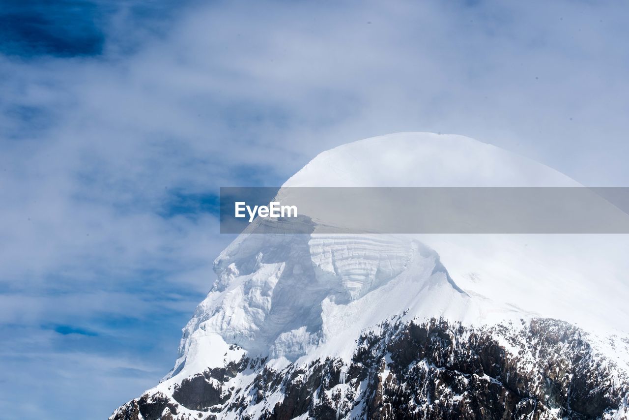 Low angle view of snowcapped mountain against sky