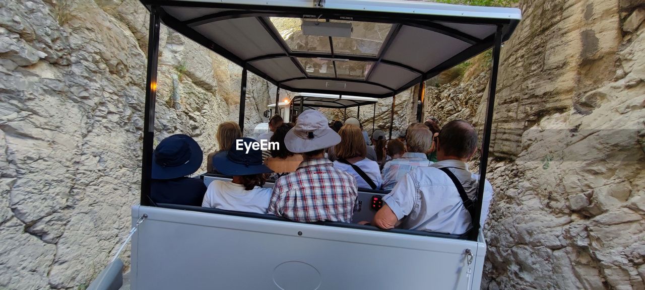 men, group of people, adult, architecture, women, leisure activity, technology, togetherness, sitting, day, lifestyles, casual clothing, travel, transportation, young adult, built structure, outdoors, friendship, clothing, person, nature, vehicle, communication, mode of transportation