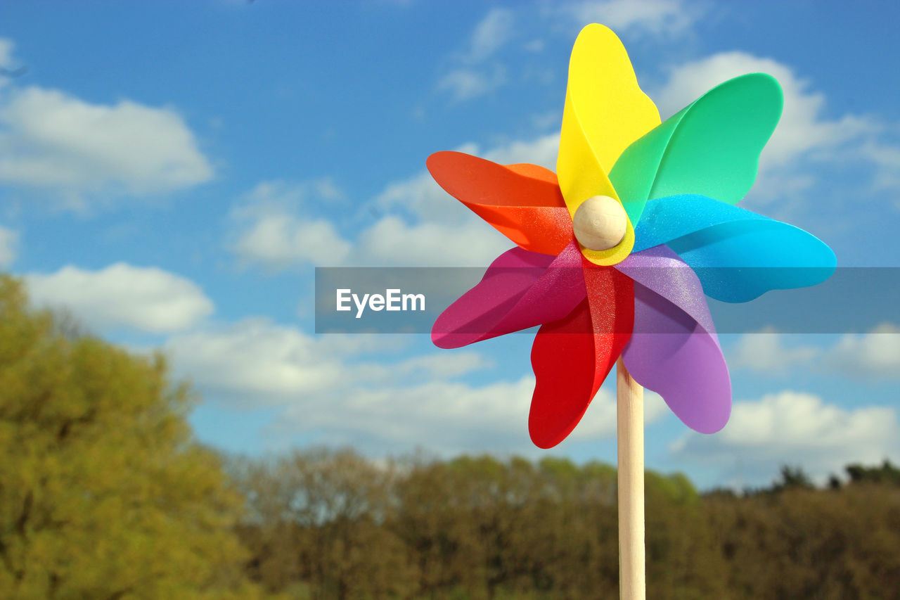 Multi colored pinwheel toy against sky