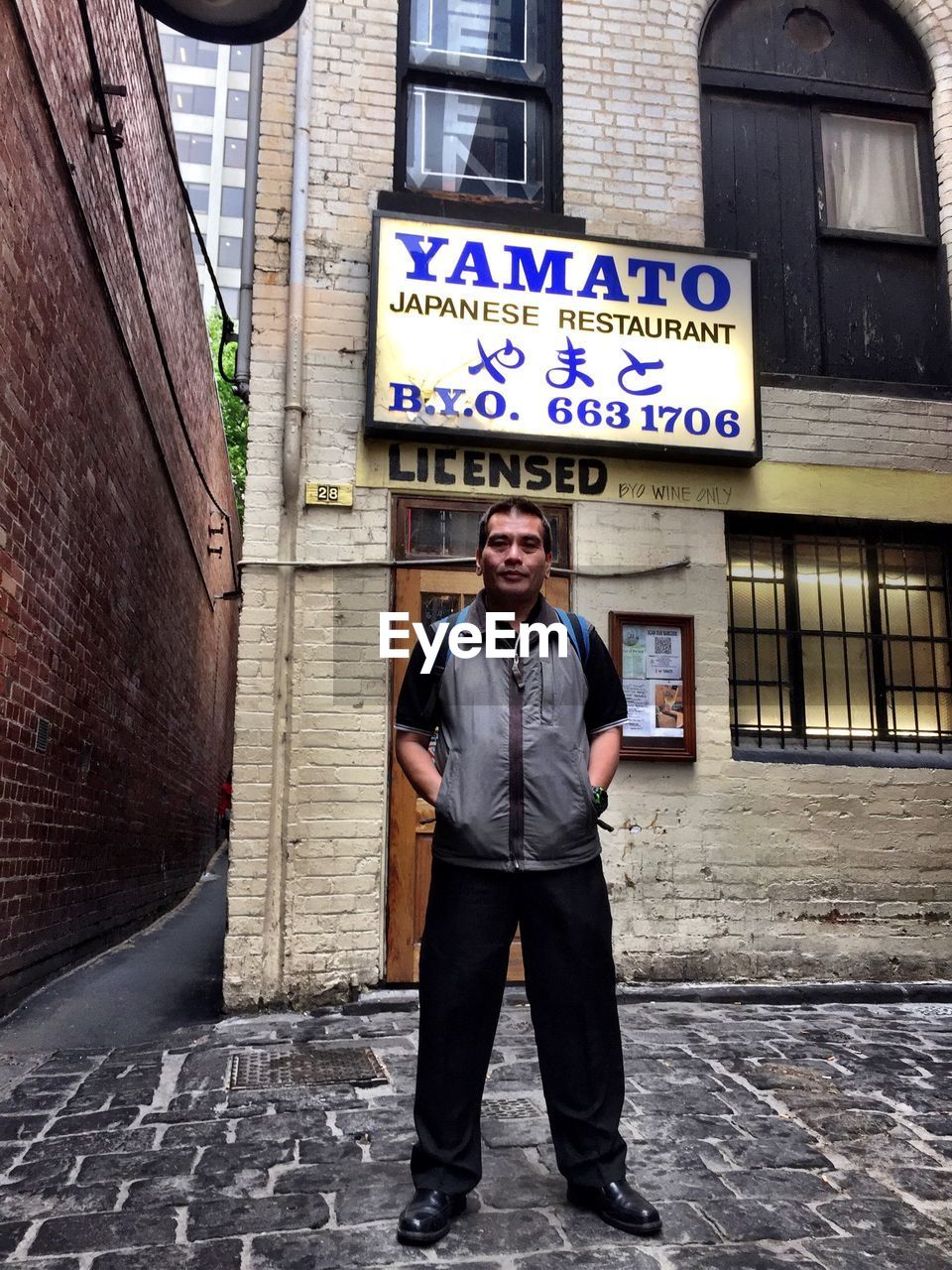 WOMAN STANDING IN FRONT OF BUILDING