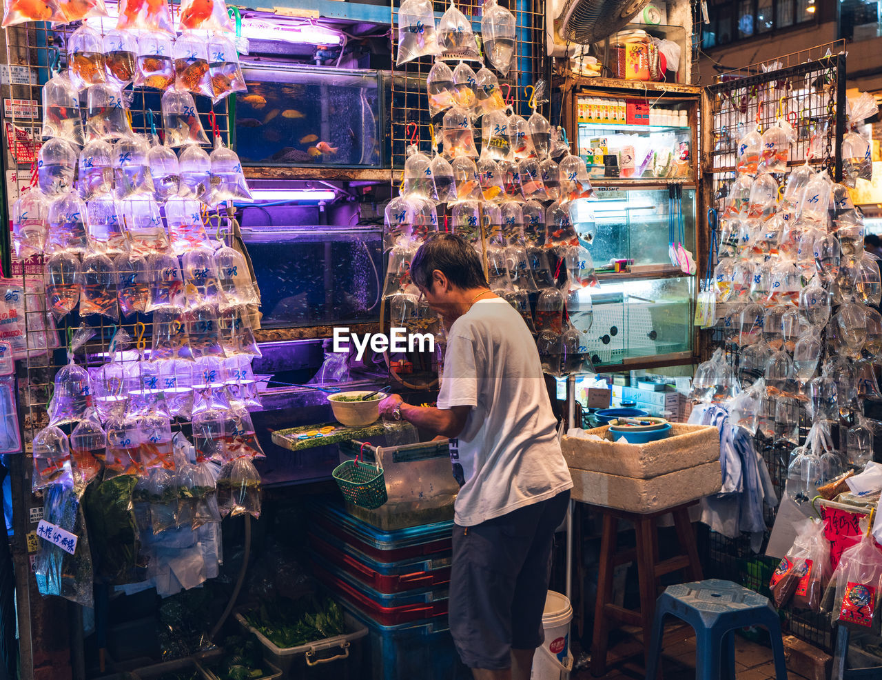 MAN STANDING IN MARKET STALL