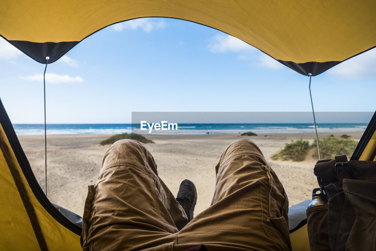 Low section of person relaxing on beach