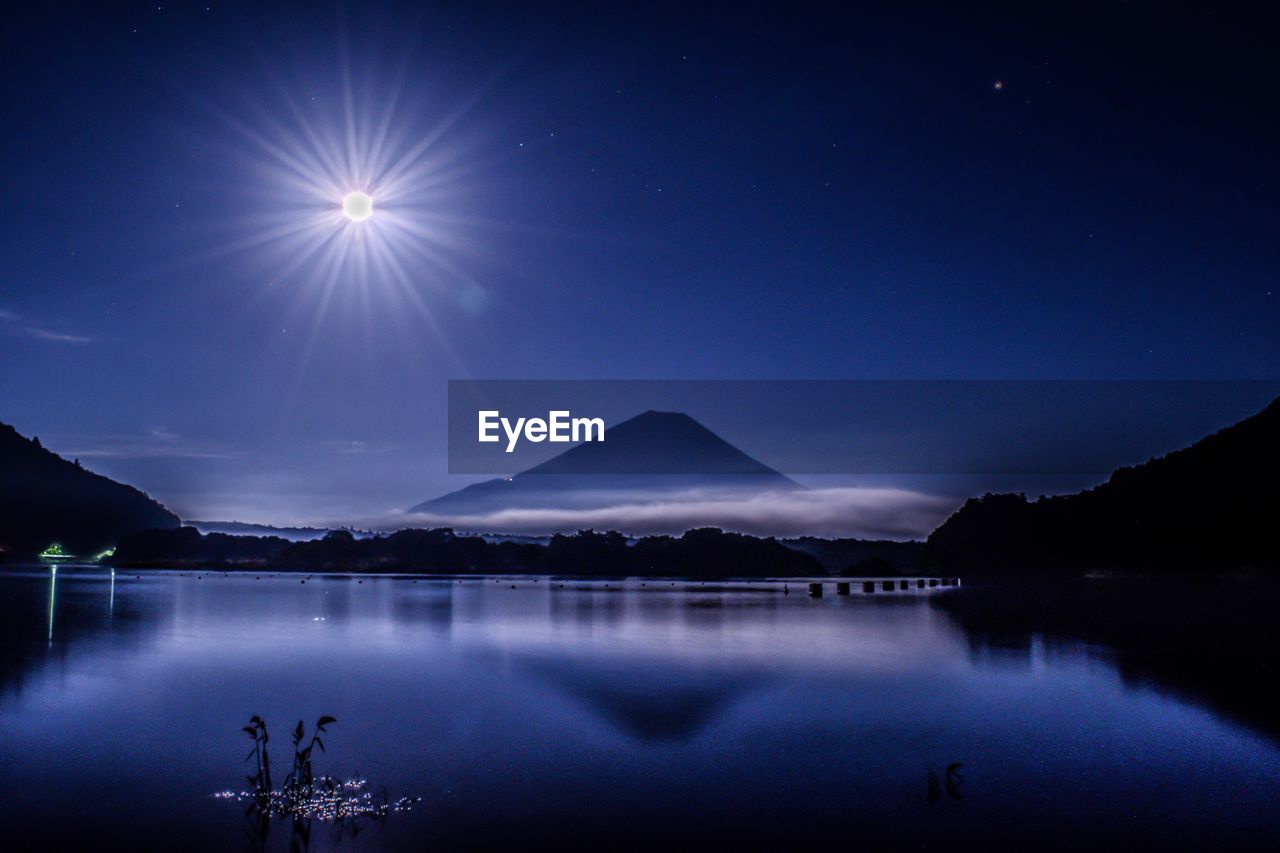 Scenic view of lake against sky at night