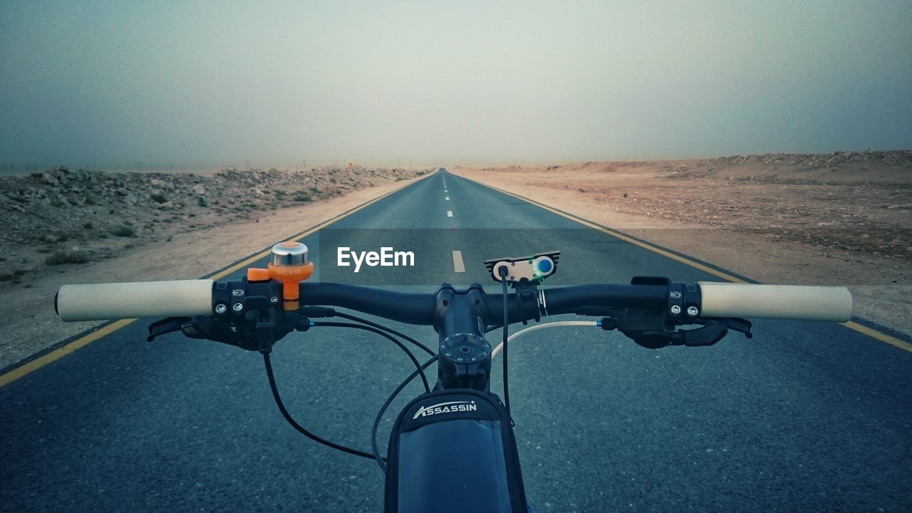 BICYCLE PARKED ON ROAD IN CITY